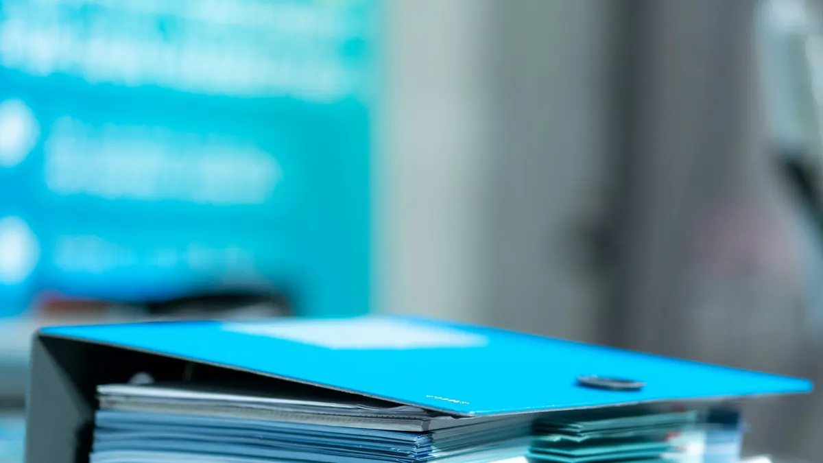 A thick blue binder stuffed with papers on a desk, representing the signed letter, receipts, and contract records a U.S. owner keeps after canceling a timeshare