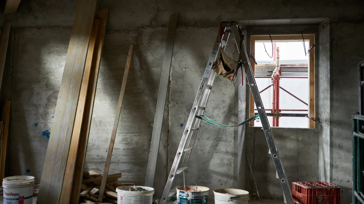 A resort interior under renovation with a ladder, lumber, and paint buckets, representing the work that triggers a timeshare special assessment