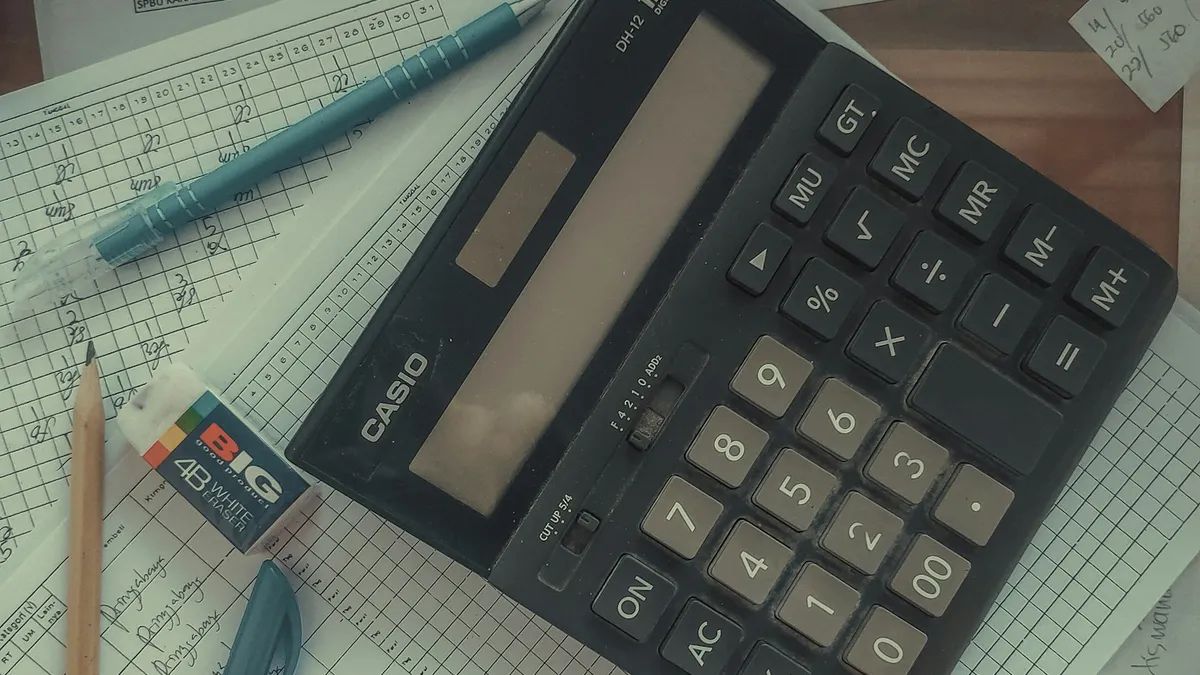 A calculator resting on handwritten ledgers and columns of figures, representing a U.S. owner checking the numbers behind a timeshare special assessment