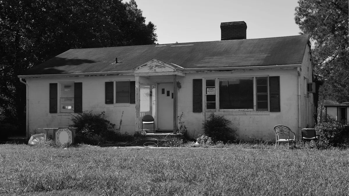 A weathered single-story house in grayscale, representing the foreclosure process that can follow unpaid timeshare obligations