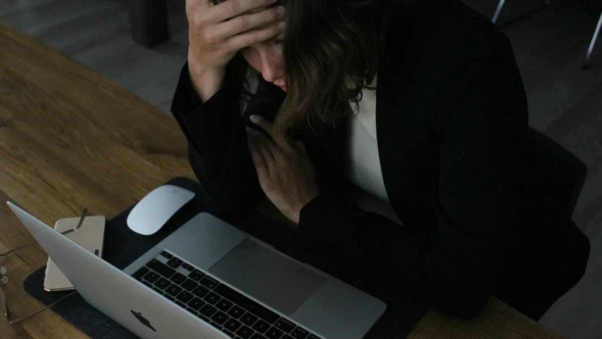 A person sitting at a desk with head in hand after a call, representing a U.S. timeshare owner targeted by an unsolicited resale or exit scam