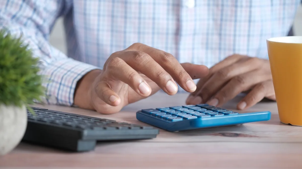 Owner using a calculator to total the true financial cost of a timeshare purchase