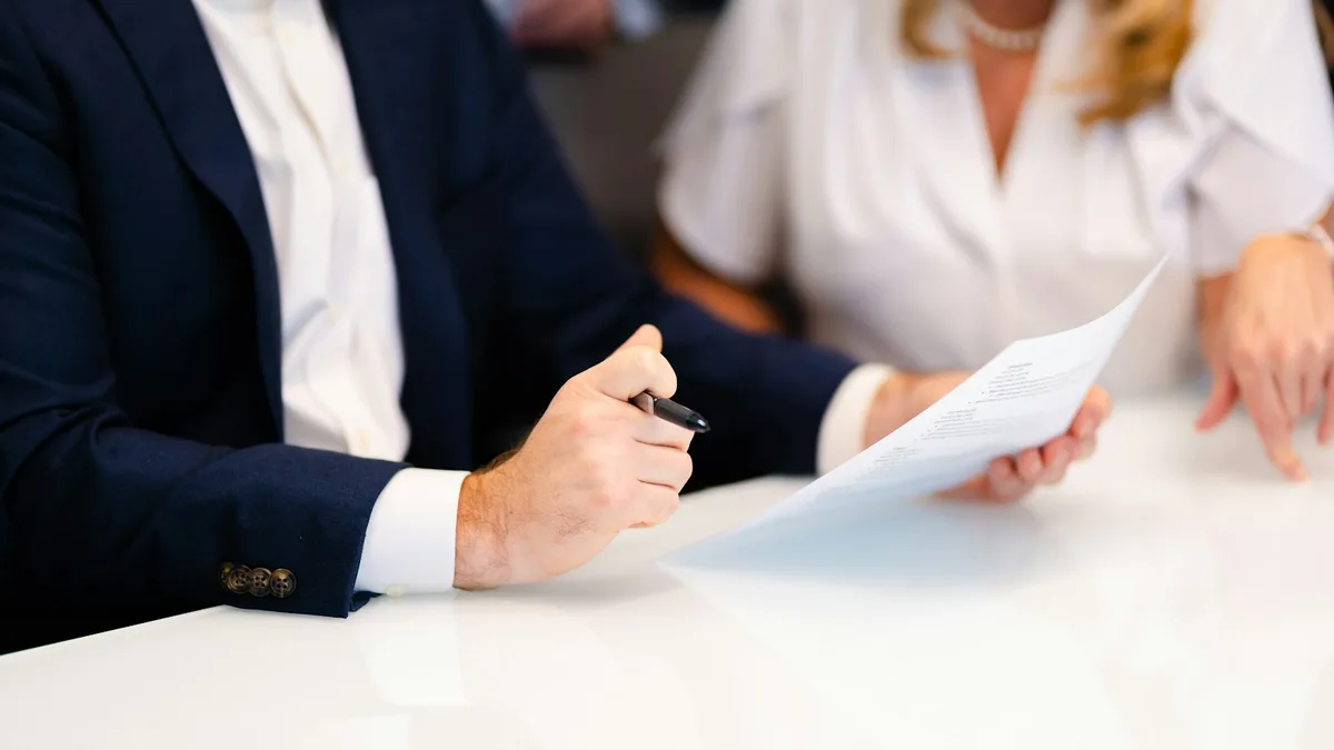 Two professionals reviewing a document across a table during a consultation, representing legal representation for a U.S. timeshare owner