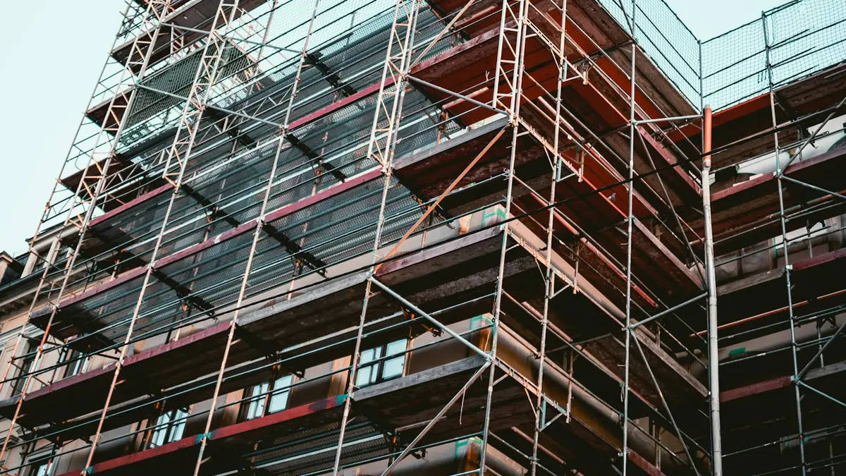 A building facade wrapped in scaffolding during major structural work, representing the kind of large resort repair that U.S. timeshare owners fund through a special assessment