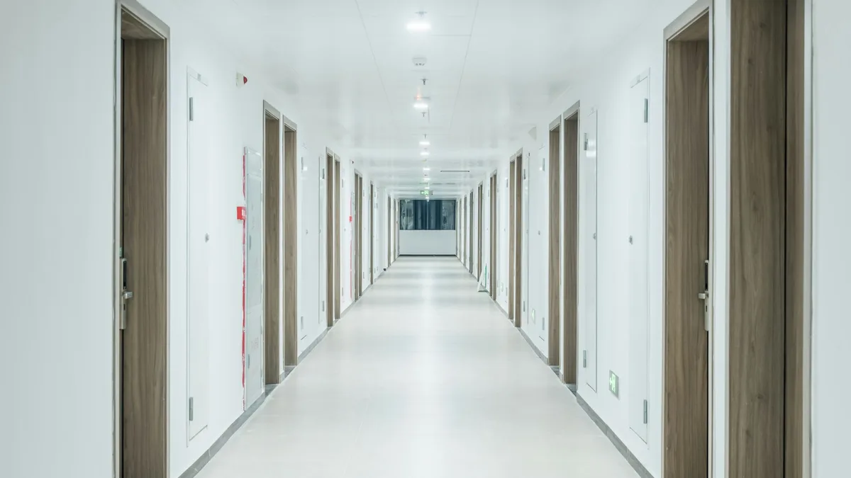 A bright resort corridor lined with numbered doors, representing the four exit paths available to a U.S. owner whose timeshare will not sell