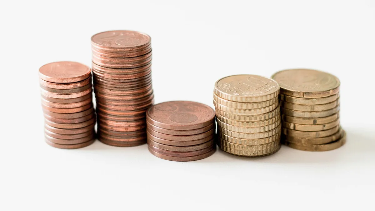 Stacks of coins arranged in ascending height, representing the compounding hidden costs of U.S. timeshare ownership that rise year after year